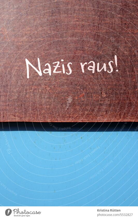 nazis raus! steht auf braunem schild an blauer wand Antifaschismus antifaschistisch protestieren gegen nationalsozialismus Faschismus Rechtsextremismus
