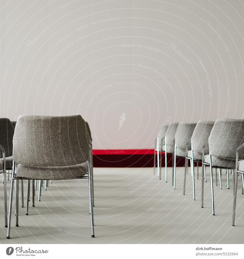 leere Stuhlreihen in einem Vortragssaal mit roter Bühne Vortragsraum Podium Design modern Freiraum oben vortragen Auditorium Vorlesungsraum Seminar Universität