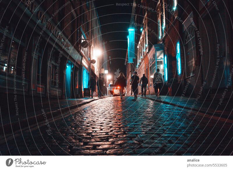 Gruppe von Menschen, die nachts die Straße hinaufgehen Menschengruppe Personengruppen laufen Zusammensein Straßenbeleuchtung Nacht Nachtleben Baustein Großstadt