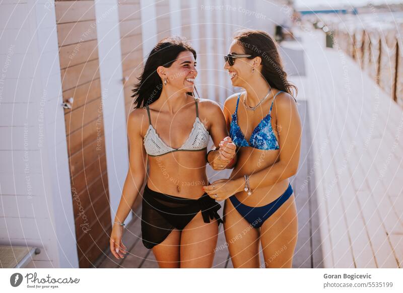 Lächelnde junge Frauen im Bikini genießen den Urlaub am Strand Erwachsener attraktiv Kaukasier Bekleidung Tag Emotion Mode Freunde Freundschaft Spaß Freundinnen