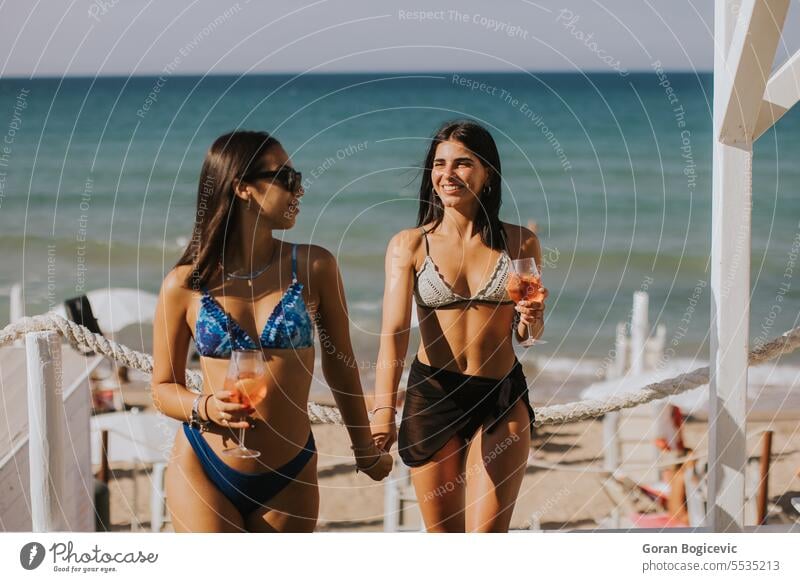 Lächelnde junge Frauen im Bikini genießen den Urlaub am Strand Erwachsener Bekleidung Tag trinken Emotion Mode Fröhlichkeit Feiertag Italien Freizeitaktivitäten