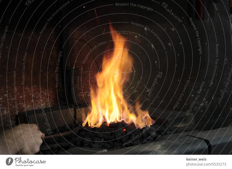 Feuer in der Schmiede auf heißen Kohlen Flamme Hand schüren einheizen Handwerk Schmiedehandwerk schmieden Werkstatt Metall Hufschmied Fähigkeit Industrie Beruf