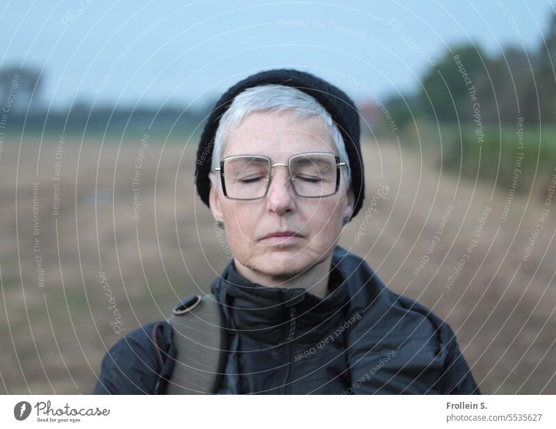 Weites Land | Traumhaft Portrait geschlossene Augen Landschaft Jacke Horizont Frau Herbst entspannt träumen Schwarze Mütze Schwarze Jacke Brille