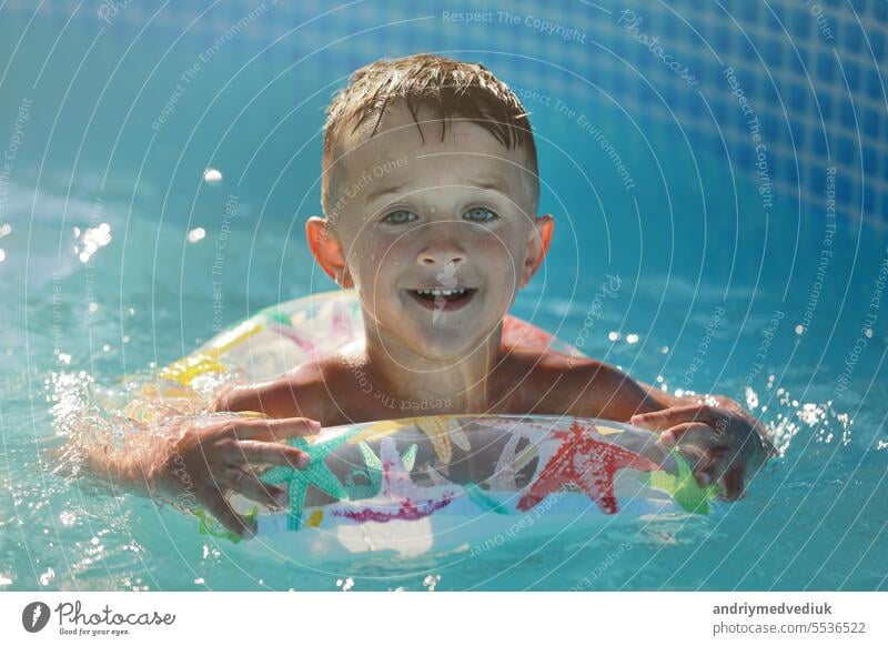 Portrait lächelnd Junge im Schwimmbad, Kind mit aufblasbaren Ring. Sommerferien oder Unterricht. Sommerzeit und Schwimmen Aktivitäten für glückliche Kinder am Pool