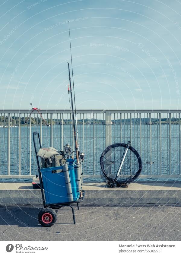 Angler haben ihre Ausrüstung an einer Seebrücke aufgebaut. fischen fischer fischerei fischerausrüstung angeln angler see wasser gewässer blau trolli