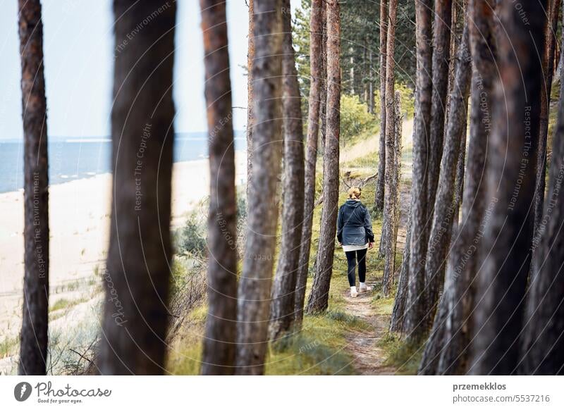 Frau beim Wandern im Wald am Meer. Person verbringt aktiv ihren Urlaub. Sommerreise. Genießen Sie zu Fuß am Meer Küste. Outdoor-Aktivität Ferien Ausflug MEER