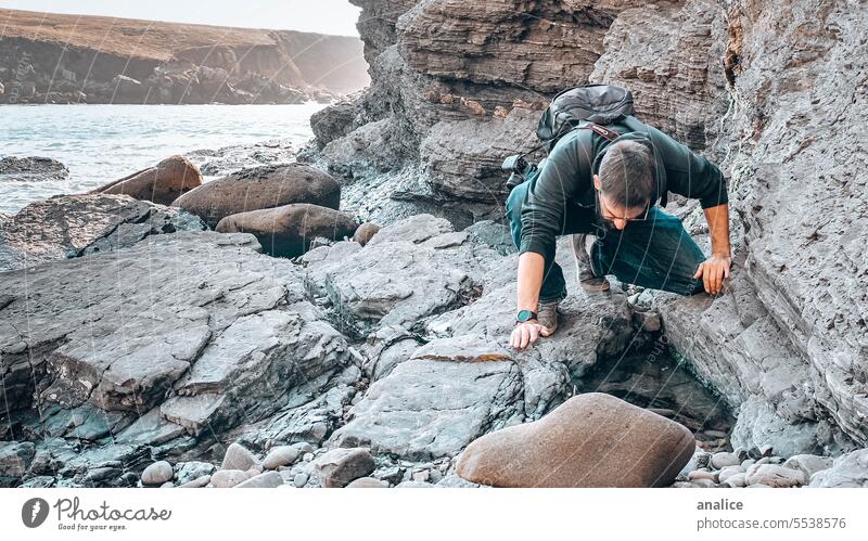 Mann erkundet felsige Umgebung Wanderung Reisender erkunden erkundend Entdecker suchend durchsuchend Neugier neugierig Natur Felsen Steine Person Mensch