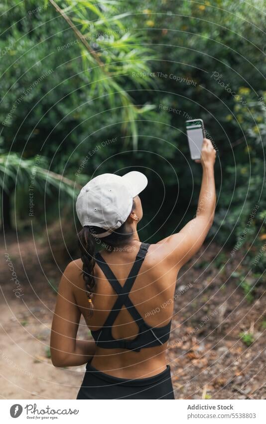 Weiblicher Wanderer macht Selfie im Wald Frau Lächeln Pause ruhen Wochenende reisen Smartphone Wälder Glück Hut Selbstportrait froh Reisender Baum Natur Mobile