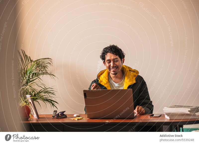 Mann arbeitet am Laptop am Tisch Telearbeit benutzend Telefon Anschluss Inbetriebnahme online abgelegen Mobile männlich freiberuflich modern Internet Beruf