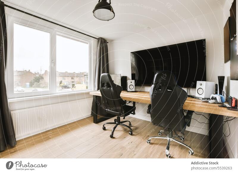Heimbüro mit Möbeln und Computer Heimarbeitsplatz Fernsehen Schreibtisch leer Stuhl groß Fenster hell Appartement Gardine schwarz FERNSEHER Bildschirm