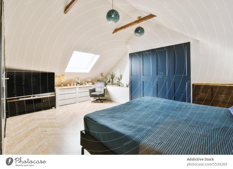 Schlafzimmer mit blauem Bett, Kleiderschrank und Fernseher Fernsehen modern Dachboden Loft Fenster Stuhl Zimmerpflanze Wohnkultur FERNSEHER Bildschirm weiß Wand