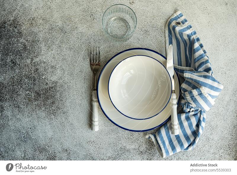 Minimalistisches rustikales Tischset auf grauer Oberfläche Teller Serviette Dekor dienen Geschirr Essgeschirr Ordnung Dekoration & Verzierung Utensil Keramik