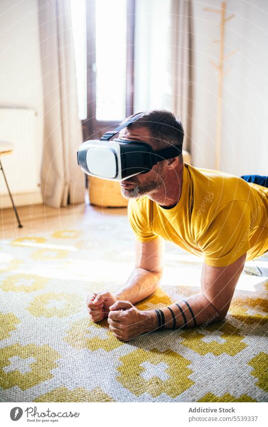 Mann mit VR-Brille beim Training zu Hause Yoga Headset Virtuelle Realität benutzend Hallo Technik männlich simulieren Technik & Technologie futuristisch