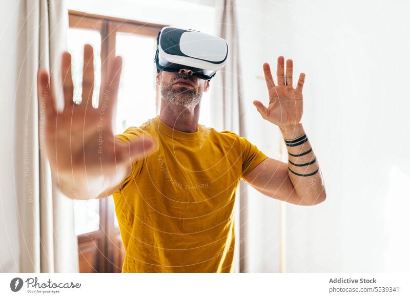 Mann mit VR-Headset trainiert in hellem Raum Virtuelle Realität Training sportlich Übung benutzend Hallo Technik männlich simulieren Technik & Technologie