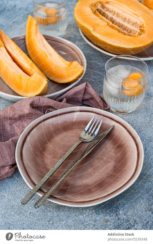 Frische Orangen-Moschus-Melone in Scheiben geschnitten und mit Melonenkugeln auf dem Tisch serviert orange frisch Frucht Glas gesunde Ernährung Eis lecker