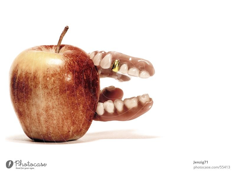 Fest zubeißen. Goldzahn Prothese Zahnersatz Haftcreme Apfel Frucht Ernährung Zähne