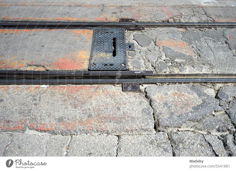 Schienen und Gleise der Straßenbahn zwischen altem grauen und bröckelndem Pflasterstein in einer Fußgängerzone bei Sonnenschein in Bursa am Uludag Gebirge in der Türkei