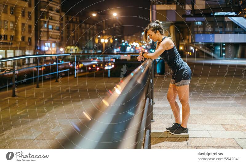Junge blonde Läuferin, die nach dem Training ihren Trainingsfortschritt auf einer Smartwatch-Anwendung überprüft Frau Überprüfung klug zuschauen smartwatch App