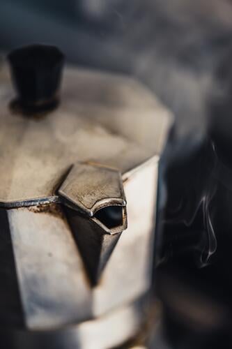 Detailaufnahme eines italienischen Espressokochers mit aufsteigendem Dampf Kaffeemaschine heiss Getränk Heißgetränk Kaffeepause Kaffeetrinken Nahaufnahme