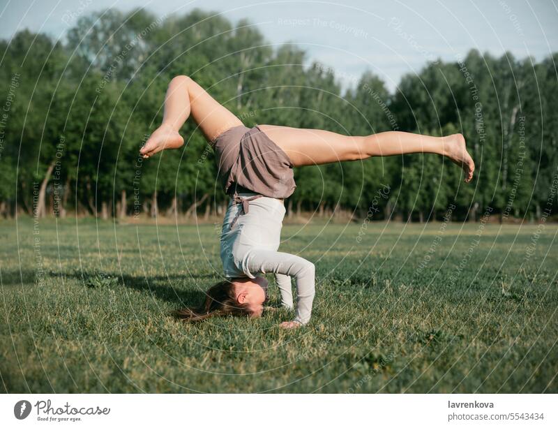 Erwachsene Frau übt Yoga im Freien, Unterarm-Balance-Pose Pincha Mayurasana aktiv Körper Sommer Natur Training Sport strecken Kunstturnen Aerobic schlank Park