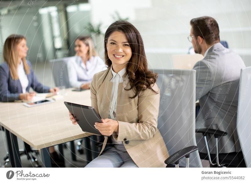 Junge Frau mit digitalem Tablet in einem modernen Büro vor ihrem Team Erwachsener attraktiv schön Business Geschäftsfrau lässig heiter Mitteilung Unternehmen