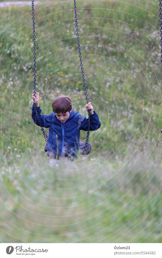 Kind auf der Schaukel schaukeln Kindheit Natur Wiese Spielplatz Freude Späße Glück Sommer