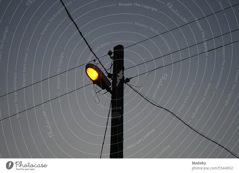 Stromleitungen mit Straßenbeleuchtung an einem Leitungsmast am Abend im Dorf Maksudiye bei Adapazari in der Provinz Sakarya in der Türkei maksudiye adapazari
