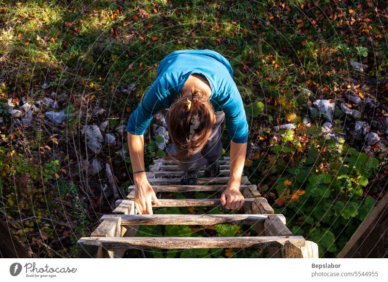 Erwachsene Frau klettert auf eine Holzleiter Fotografie Farbbild Erwachsener Holz - Material eine Person Laufmasche Menschen Nur eine Frau Nur Frauen