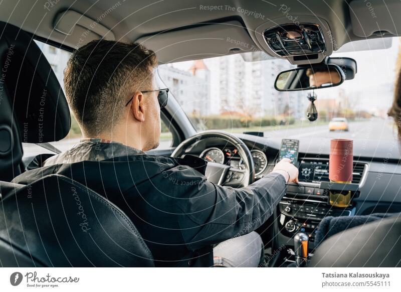 Ein Mann benutzt während der Fahrt ein in der Halterung installiertes Telefon Verwendungen Navigator Anwendung Handy fahren PKW Smartphone Gps Schifffahrt