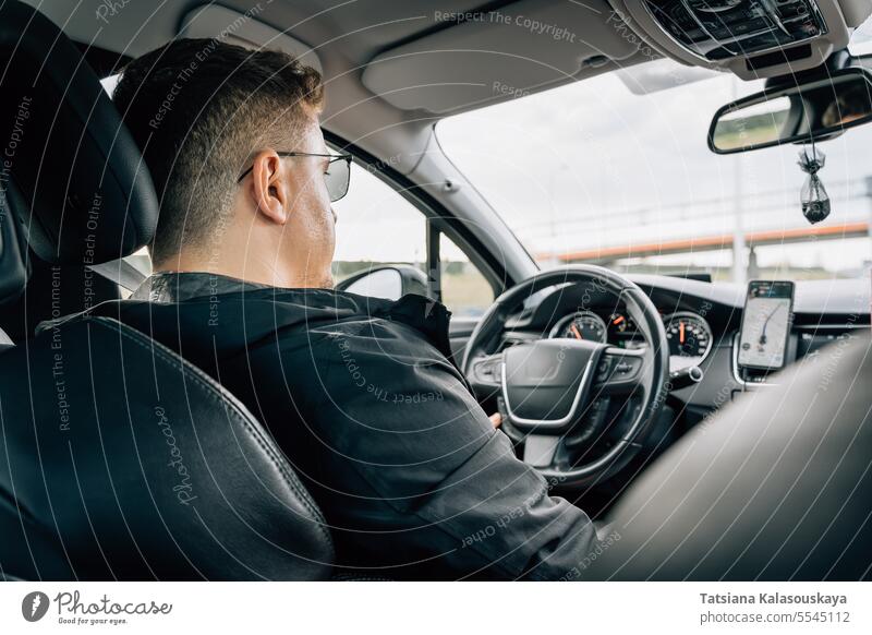 Ein Mann fährt ein Auto mit einer auf einem Smartphone installierten Navigationsanwendung Verwendungen Navigator Anwendung Handy fahren PKW Gps Schifffahrt