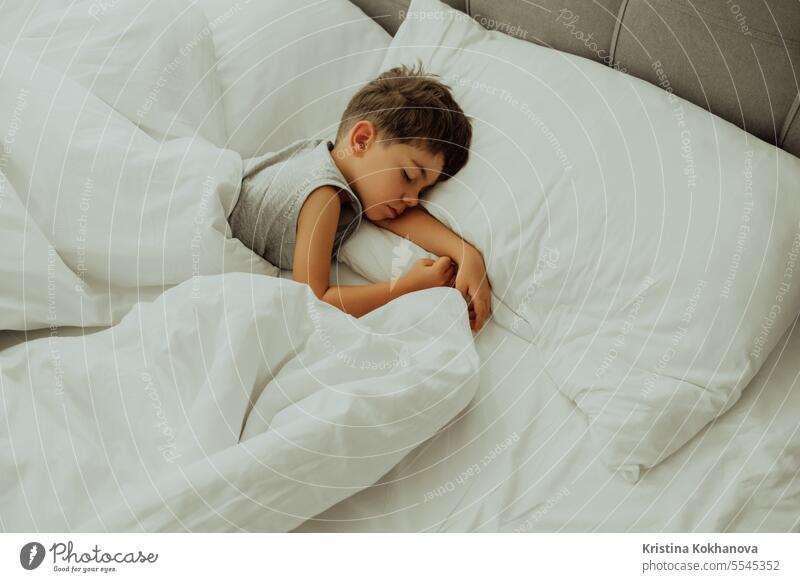 Ruhiges kleines Kind schläft gut in einem bequemen Bett. Junge in hellem, gemütlichem Schlafzimmer. Kindheit niedlich bezaubernd schlafend Kaukasier träumen