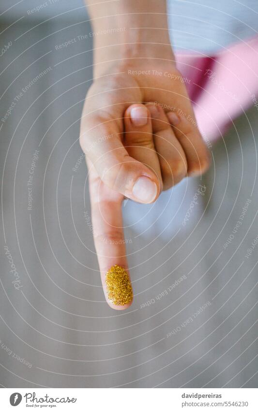 Unbekanntes Kind zeigt Finger mit goldenem Glitter, der aus schädlichen kleinen Kunststoffen besteht unkenntlich Mikro zeigend Mikroplastik Hand Verbot