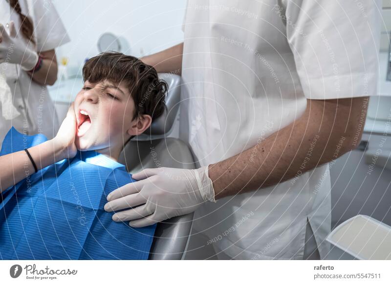 Kleiner Junge mit Zahnschmerzen schaut traurig auf seinen Zahnarzt Zahnmedizin Zähne Schmerz geduldig Person Klinik dental Behandlung Stuhl Büro Check-up Frau