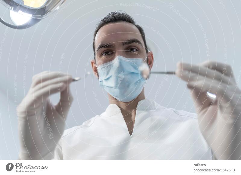 Niedriger Blickwinkel eines männlichen Zahnarztes, der die Untersuchung durchführt und die Mundgesundheit des Patienten überprüft Zähne Hohlraum Klinik klinisch