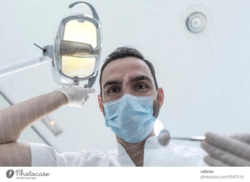 Niedriger Blickwinkel eines männlichen Zahnarztes, der die Untersuchung durchführt und die Mundgesundheit des Patienten überprüft Zähne Hohlraum Klinik klinisch