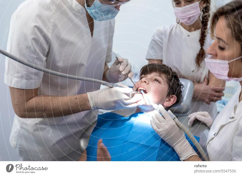 Ein Team von Zahnärzten behandelt einen kleinen Jungen in der Zahnklinik für Kieferorthopädie Zahnarzt Klinik Medizin Zähne Behandlung kieferorthopädisch