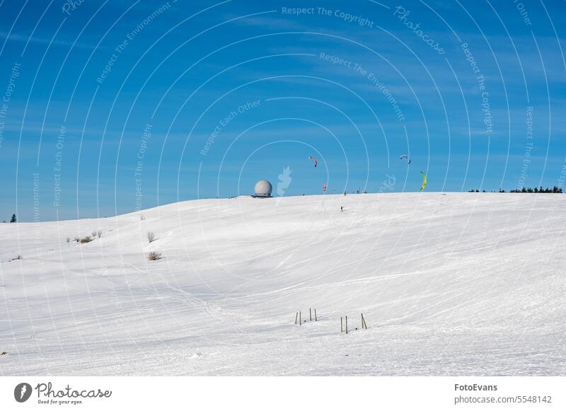 Kitesurfen auf der Wasserkuppe mit Radome im Schnee bei blauem Himmel Winterzeit Kiting Natur Radar Deutschland Tag Dom Milan Snowboard außerhalb Bewegung