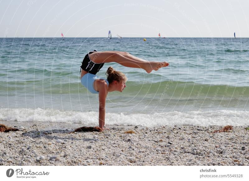 Turnerin am Strand in Turnpose turnerin strand turnrn gymnastik yoga contorsion sport bewegung Fitness Gesundheit Sport-Training wellen meer surfer surfen segel