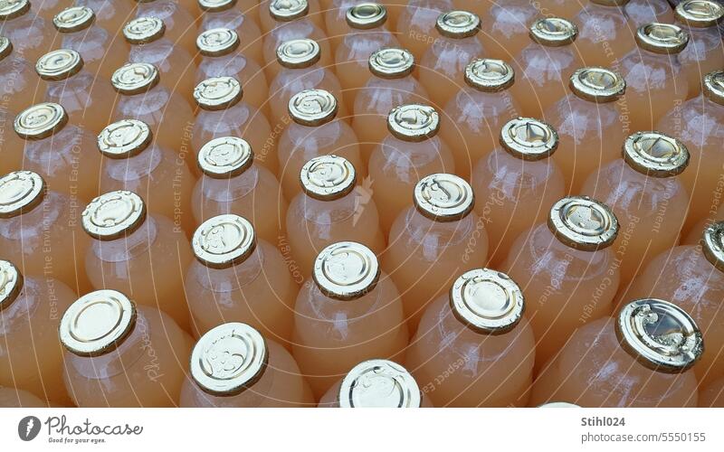 ganz viele Apfelsaftflaschen - regennass Saftflaschen Getränk trinken Nahaufnahme Flasche Erfrischungsgetränk Lebensmittel Durst Flüssigkeit Regentropfen Reihe
