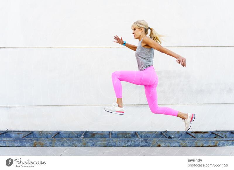 Frau in Sportkleidung läuft bei Tageslicht auf der Straße Läufer Training joggen Übung laufen Fitness Herz braune Haare nackte Schultern Leggings
