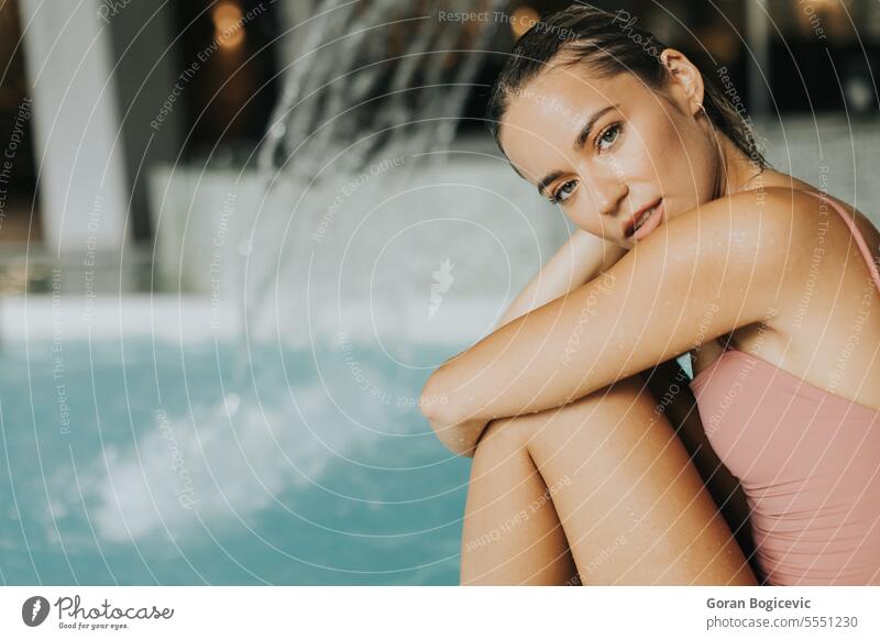 Junge Frau entspannt sich am Hallenbad Schönheit Schwimmsport Wohlbefinden im Innenbereich Beckenrand aussruhen Erholung Menschen Wasser Blick