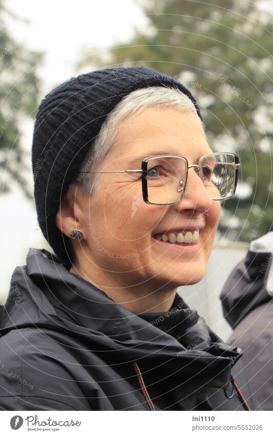 Weites Land |Profilansicht einer lachenden Frau mit Brille und Mütze Mensch Erwachsene Porträt zur Seite schauend Frauengesicht freundlich Freundlichkeit