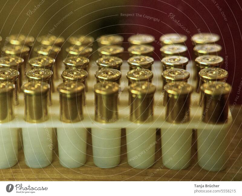 Goldene Patronen in Reih und Glied Munition Aufbewahrung Munition Gewehrpatronen Pistolenpatronen Verteidigung Schußwaffen Halterung für Patronen