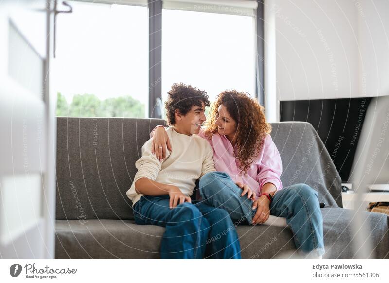Glückliche Mutter und Sohn sitzen auf dem Sofa im Wohnzimmer zu Hause echte Menschen Erwachsener Appartement Bonden Junge Kind Familie Frau heimwärts