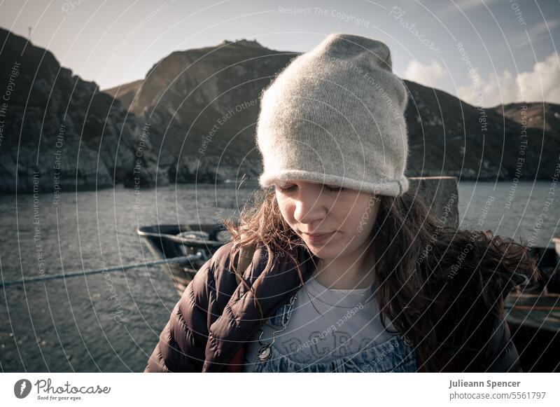 Teenager-Mädchen mit Mütze schaut auf den Boden, Meereslandschaft jung Frau Beanie MEER Klippen junges Mädchen