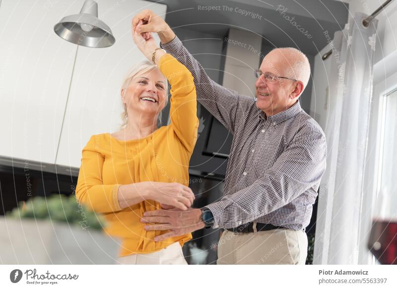 Älteres Paar tanzt und lächelt zu Hause alt Menschen Glück Senior heimwärts Liebe Spaß Tanzen Familie feiern Lifestyle Frau Mann heimisch Küche Kaukasier heiter
