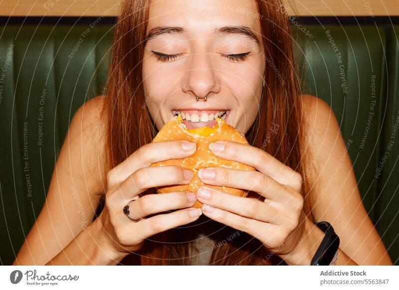 Junge Frau isst gerne Hamburger Mädchen essen Fastfood Burger jung Lebensmittel Tisch Sitzen eine Abendessen Mittagessen Snack Beteiligung Hand ungesund