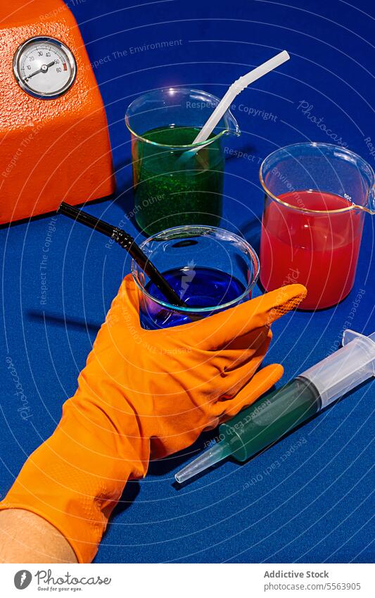 Chemische Getränke auf blauem Tisch neben Maschine und Spritze trinken bearbeitet Chemikalie Labor Cocktail chemisch Glas Stillleben kreativ konzeptionell