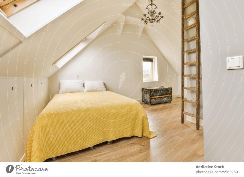 Schlafzimmer im Dachgeschoss mit gelbem Bett und Leiter Laufmasche bequem hölzern geräumig weiß Wand heimwärts Kopfkissen Textfreiraum Fenster Appartement
