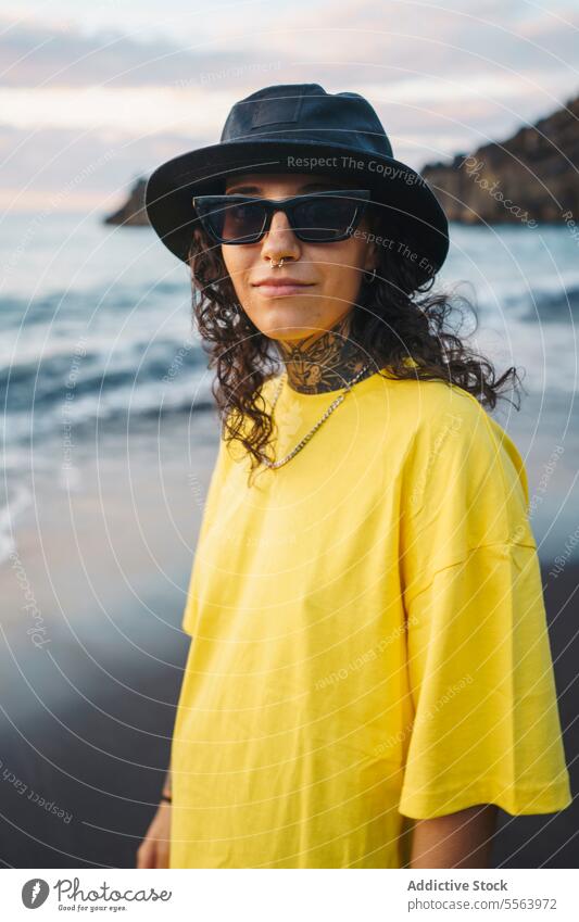 Nachdenkliche Frau mit Händen in den Taschen am Strand Porträt MEER besinnlich Meeresufer nachdenklich Windstille Küste Ufer Sand winken Natur Sonnenbrille